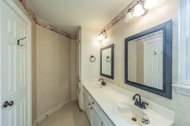 bathroom featuring a textured ceiling, double vanity, tile patterned flooring, and a sink