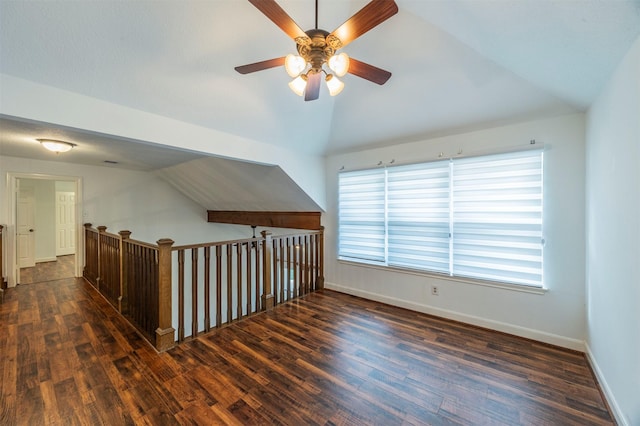 bonus room featuring a ceiling fan, lofted ceiling, dark wood finished floors, and baseboards