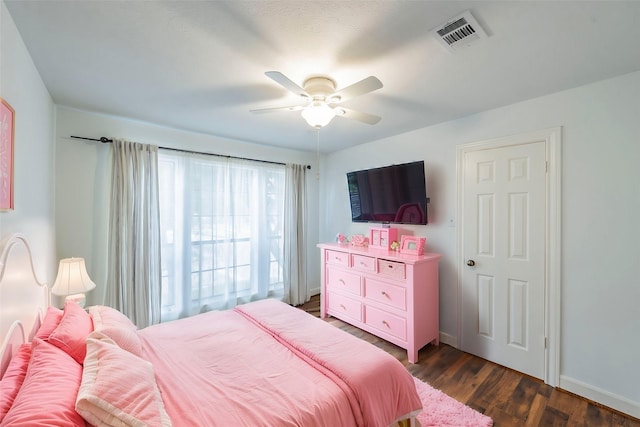 bedroom with dark wood-style floors, ceiling fan, visible vents, and baseboards