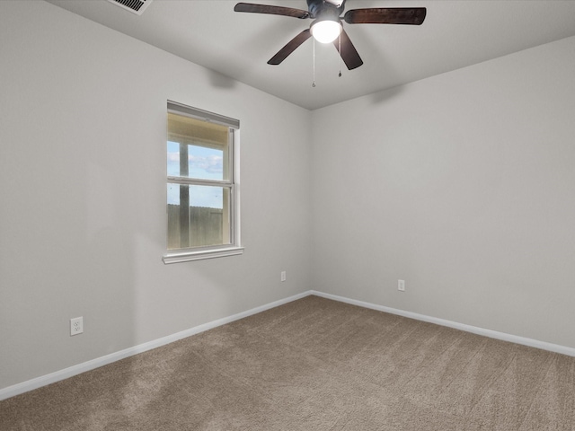 carpeted empty room with a ceiling fan and baseboards