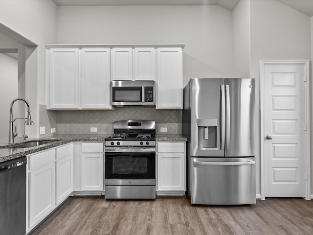 kitchen with light wood-style flooring, white cabinets, appliances with stainless steel finishes, and a sink