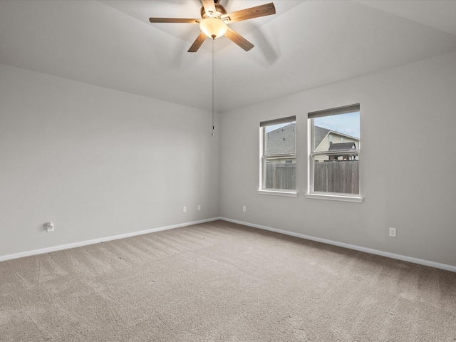 spare room with ceiling fan, baseboards, carpet, and vaulted ceiling