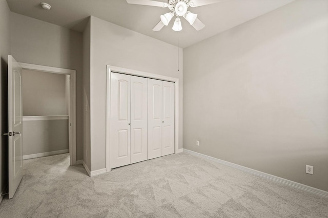 unfurnished bedroom featuring light colored carpet, a closet, and ceiling fan