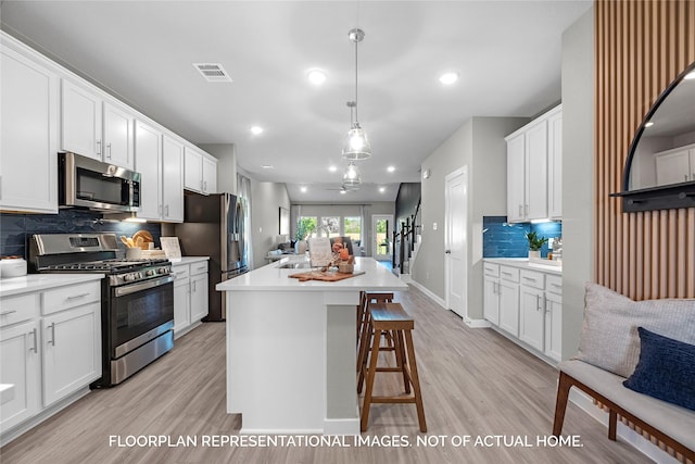 kitchen with a center island, stainless steel appliances, light countertops, and open floor plan