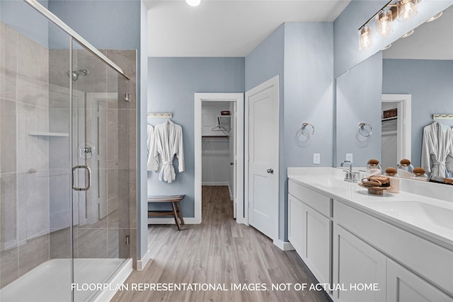 bathroom featuring wood-type flooring, vanity, and a shower with shower door