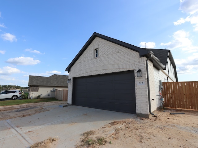 134 Spring Rose Dr, Magnolia, TX 77354 - view of home's exterior with brick siding, an attached garage, and concrete driveway