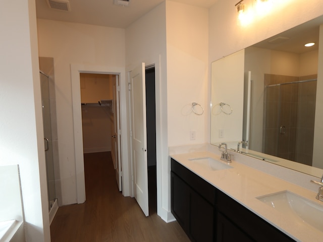 134 Spring Rose Dr, Magnolia, TX 77354 - bathroom with a shower stall, wood finished floors, double vanity, and a walk in closet