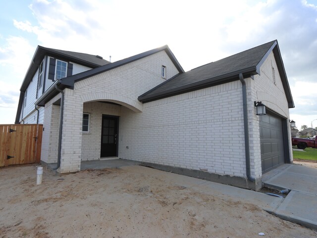 134 Spring Rose Dr, Magnolia, TX 77354 - back of house featuring brick siding and an attached garage