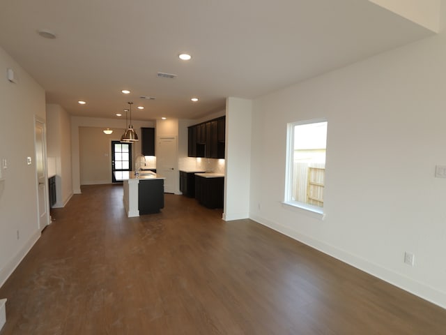 134 Spring Rose Dr, Magnolia, TX 77354 - kitchen with an island with sink, baseboards, dark wood-style flooring, recessed lighting, and light countertops