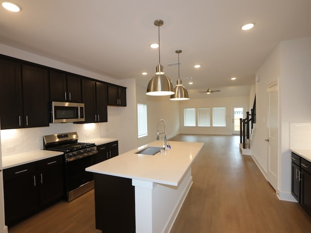 134 Spring Rose Dr, Magnolia, TX 77354 - kitchen featuring appliances with stainless steel finishes, wood finished floors, light countertops, backsplash, and recessed lighting