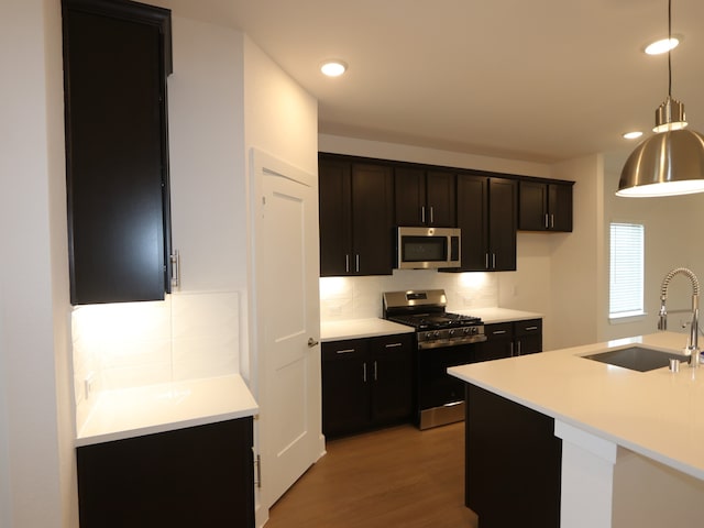134 Spring Rose Dr, Magnolia, TX 77354 - kitchen with appliances with stainless steel finishes, decorative backsplash, light wood-style flooring, hanging light fixtures, and recessed lighting