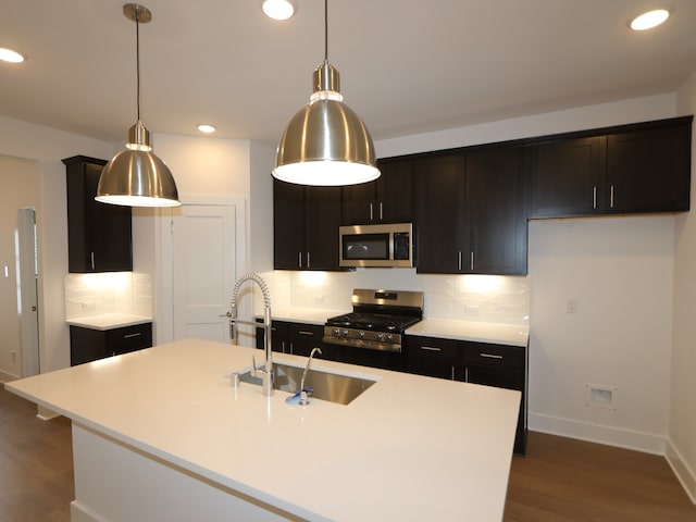134 Spring Rose Dr, Magnolia, TX 77354 - kitchen with stainless steel appliances, dark wood-type flooring, decorative backsplash, recessed lighting, and light countertops