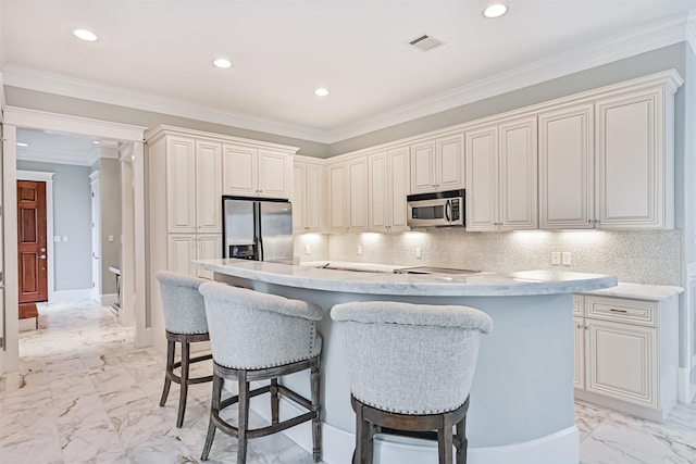 kitchen featuring a kitchen island, appliances with stainless steel finishes, a breakfast bar area, and decorative backsplash