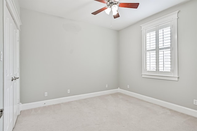 carpeted spare room featuring ceiling fan