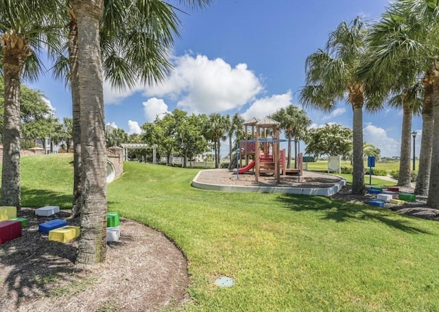view of playground with a pergola and a lawn