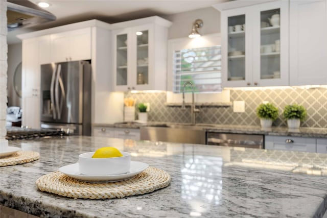 kitchen featuring white cabinetry, light stone countertops, and appliances with stainless steel finishes