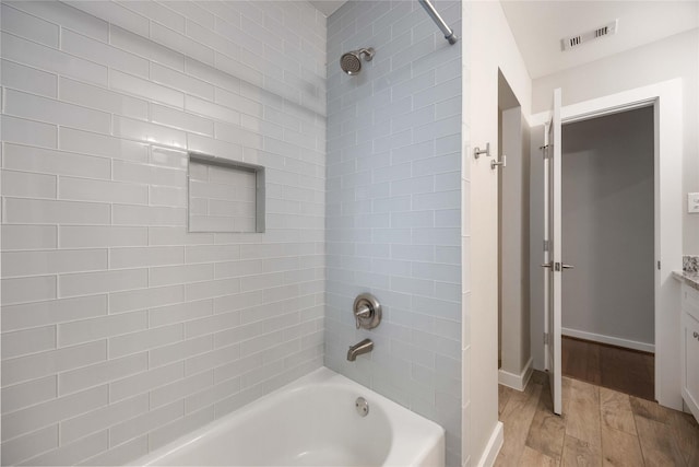 bathroom featuring tiled shower / bath combo, vanity, and hardwood / wood-style flooring