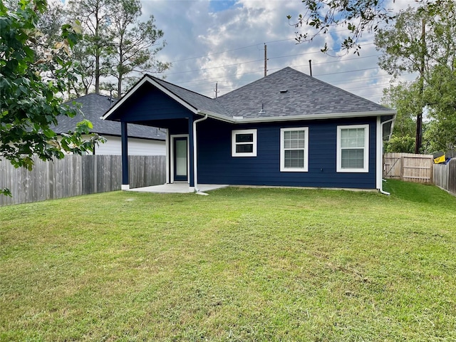 back of house with a lawn and a patio area