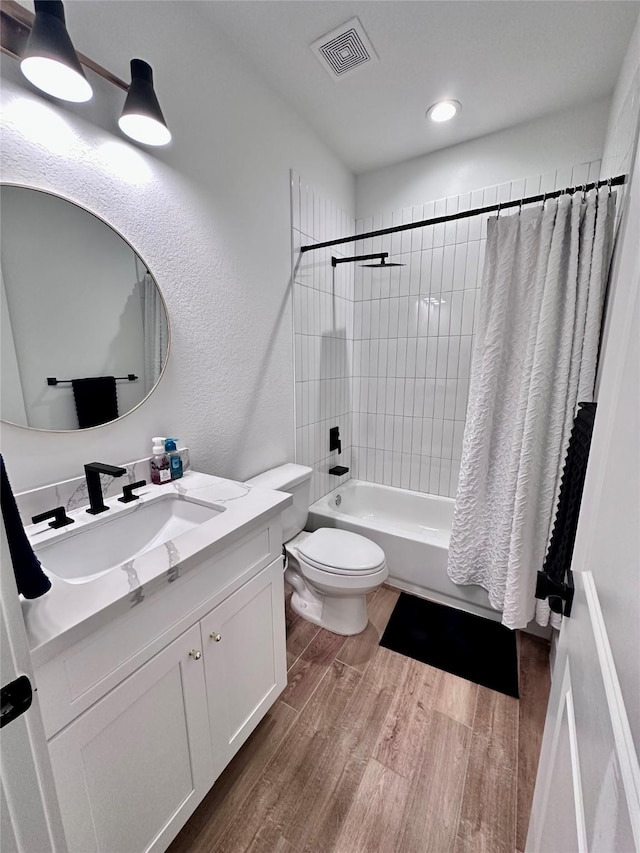 full bathroom featuring wood-type flooring, toilet, shower / tub combo, and vanity