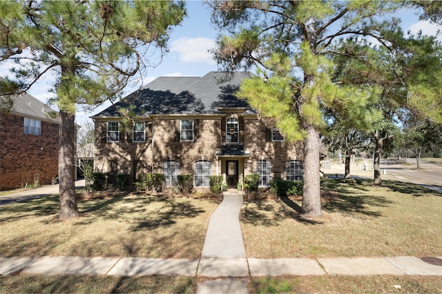 colonial-style house featuring a front lawn