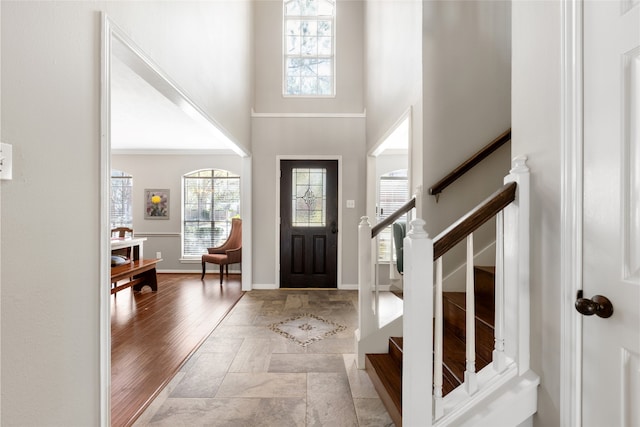 entrance foyer with a towering ceiling and light hardwood / wood-style floors