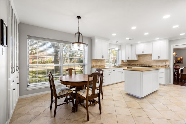 kitchen featuring hanging light fixtures, white cabinetry, a center island, and tasteful backsplash