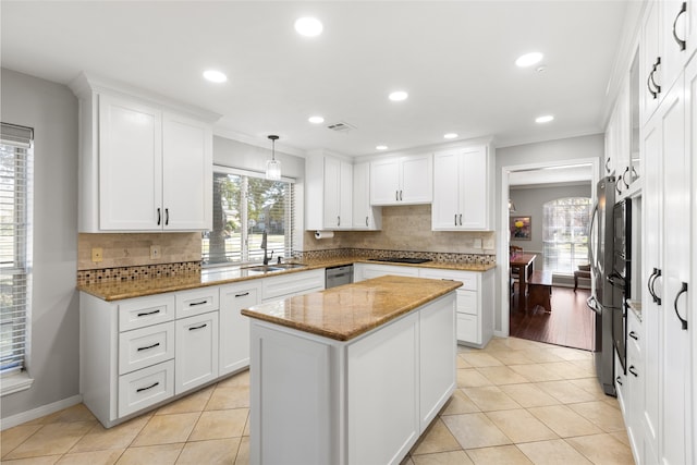 kitchen with white cabinetry, light stone countertops, sink, and a kitchen island