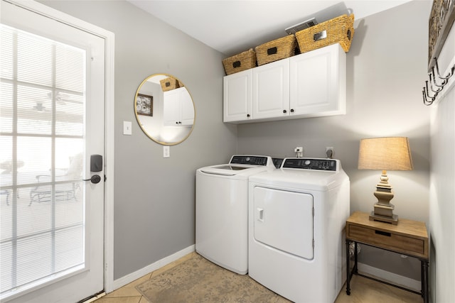 laundry room featuring separate washer and dryer, light tile patterned floors, and cabinets