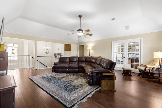 living room featuring vaulted ceiling, ornamental molding, a tray ceiling, dark wood-type flooring, and french doors