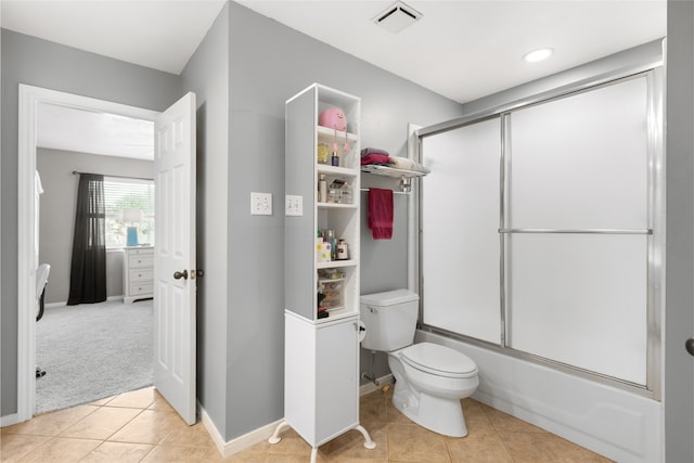 bathroom featuring toilet, tile patterned floors, and shower / bath combination with glass door