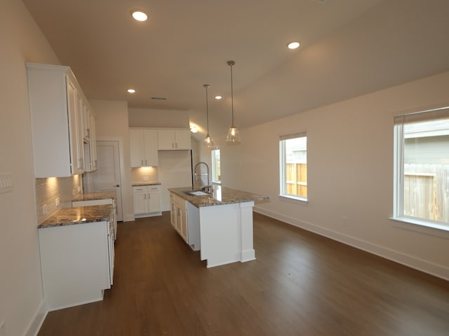 740 Autumn Cherry Trl, Magnolia, TX 77354 - kitchen with a sink, dark wood-style floors, decorative backsplash, baseboards, and dark stone counters