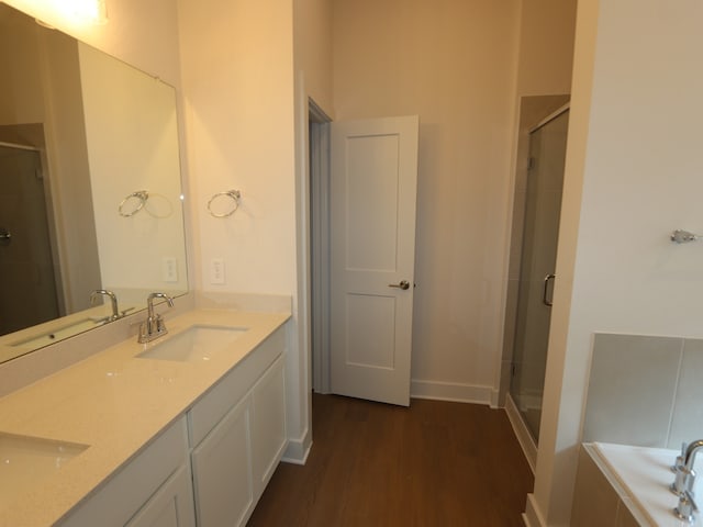 740 Autumn Cherry Trl, Magnolia, TX 77354 - full bathroom with a stall shower, double vanity, wood finished floors, and a garden tub
