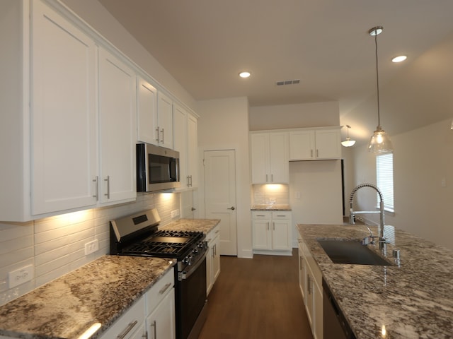 740 Autumn Cherry Trl, Magnolia, TX 77354 - kitchen featuring stainless steel appliances, light stone countertops, white cabinetry, decorative backsplash, and dark wood-style floors