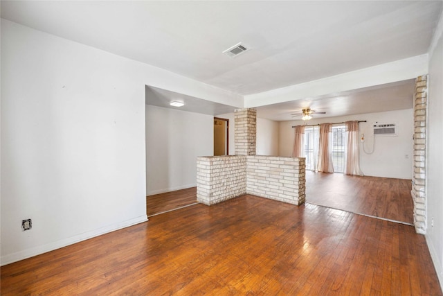 spare room with a wall mounted air conditioner, hardwood / wood-style floors, and ceiling fan