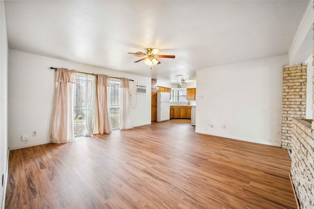 unfurnished living room featuring ceiling fan and light hardwood / wood-style floors