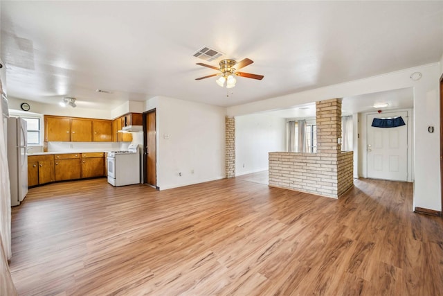 unfurnished living room featuring ceiling fan and light wood-type flooring