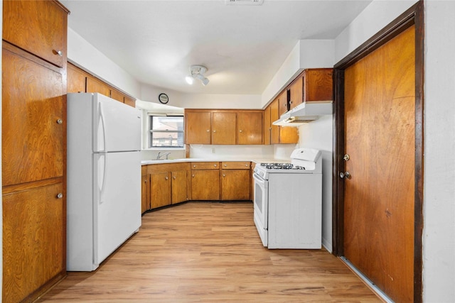 kitchen featuring sink, white appliances, and light hardwood / wood-style flooring