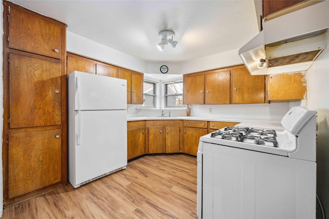 kitchen with light wood-type flooring, sink, and white appliances