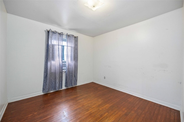 empty room with dark hardwood / wood-style flooring