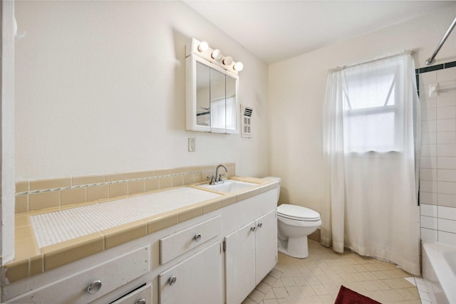 full bathroom with vanity, tiled shower / bath combo, tile patterned floors, and toilet