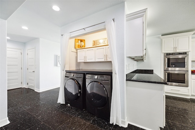 clothes washing area featuring cabinets and separate washer and dryer