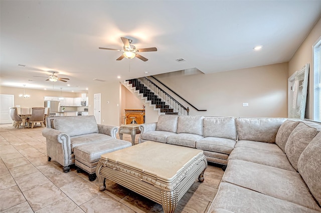 living room featuring ceiling fan with notable chandelier and light tile patterned floors