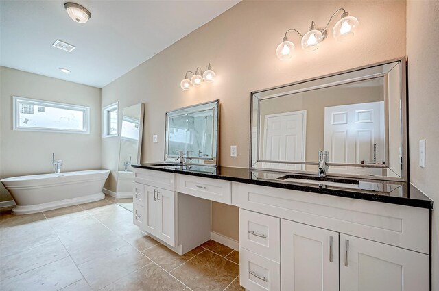 bathroom with vanity, tile patterned floors, and a tub