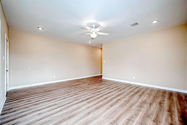 empty room with ceiling fan and light hardwood / wood-style floors