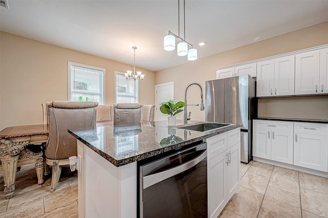 kitchen featuring pendant lighting, black dishwasher, sink, white cabinets, and a kitchen island with sink