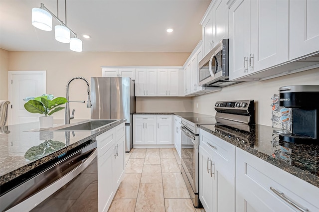 kitchen with sink, white cabinetry, dark stone countertops, pendant lighting, and stainless steel appliances