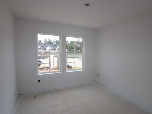 empty room with baseboards and concrete floors