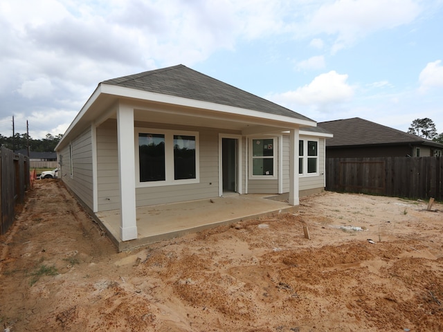 back of house featuring a fenced backyard, a patio, and roof with shingles