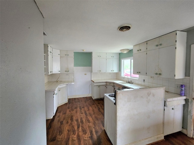 kitchen with sink, white cabinets, tasteful backsplash, and dark hardwood / wood-style floors