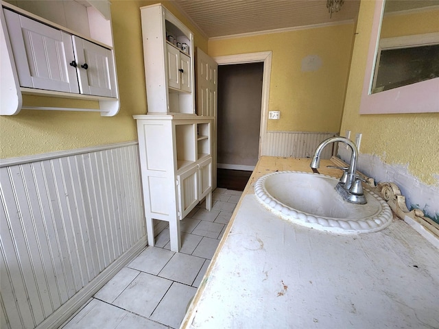 bathroom featuring tile patterned floors, sink, and wood walls